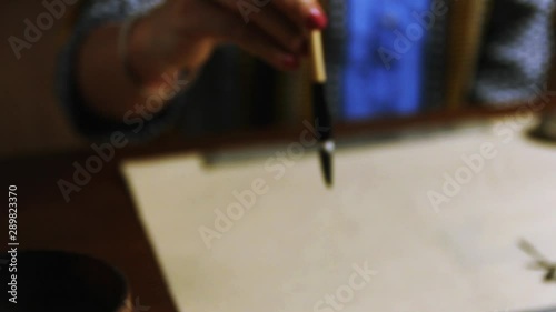 Girl writes Chinese characters (Translation from Chinese Mandarin 1: jixiang ruyi wanshi ankang- to be gratified propitiously with everything in good health, 2: fugui jixiang: wealthy and propitious) photo