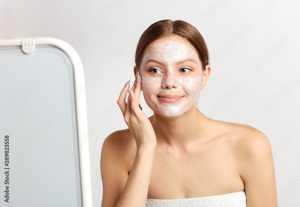 happy girl using cream and looking at the mirror. close up portrait, studio shot. close up photo, free time, leisure happy girl using cream and looking at the mirror. close up portrait, studio shot. close up photo, free time, leisure