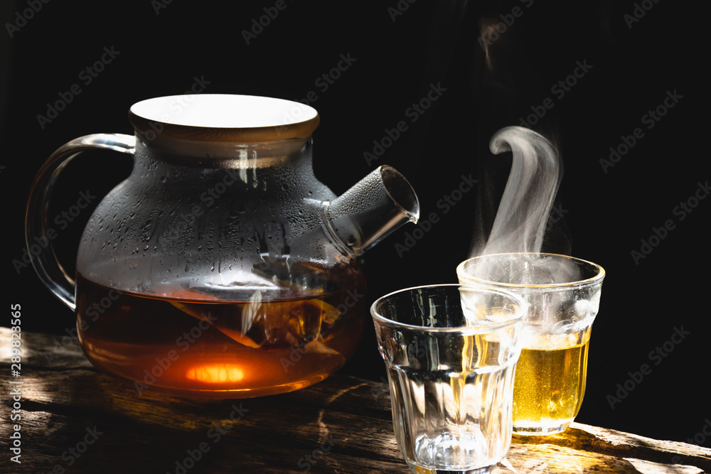 The steam from a cup of coffee or tea on the old wood table and black background, Warm drinks make good healthy, Selective focus. The steam from a cup of coffee or tea on the old wood table and black background, Warm drinks make good healthy, Selective focus.