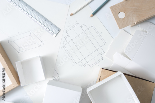 Development design drawing packaging. Desktop of a creative person making cardboard boxes.