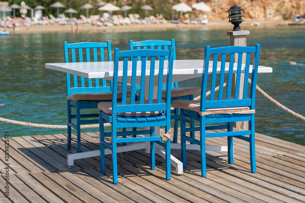 Table and chairs in beach cafe near sea water, Bodrum, Turkey. Beach cafe near sea, outdoors