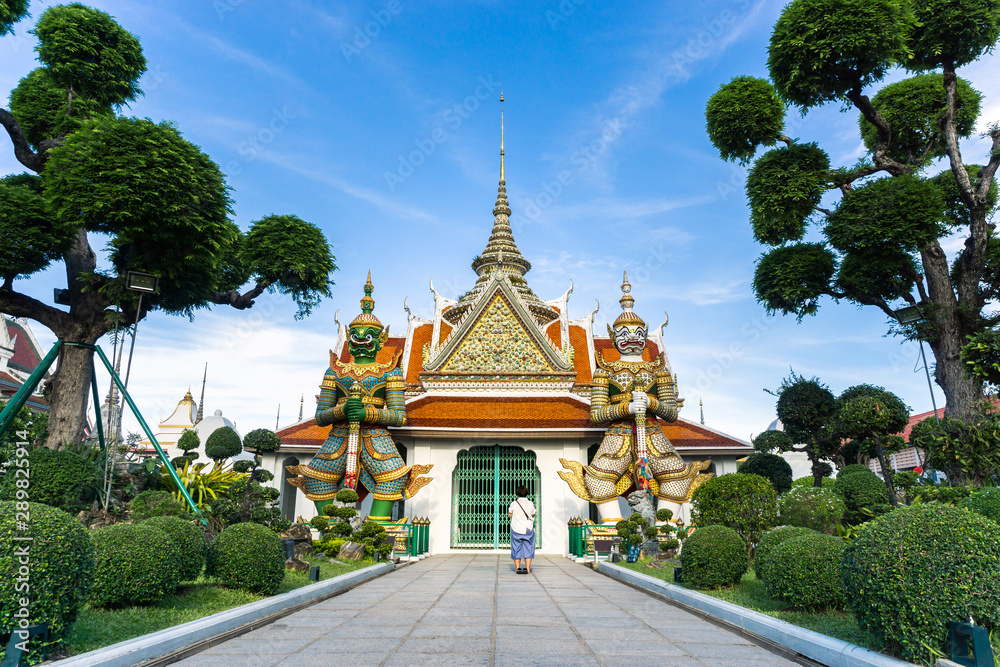 Asian woman stand praying in front of wat arun. Asian woman stand praying in front of wat arun.