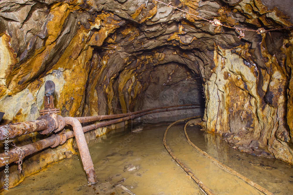 Naklejka premium Gold ore mine shaft tunnel underground with rails