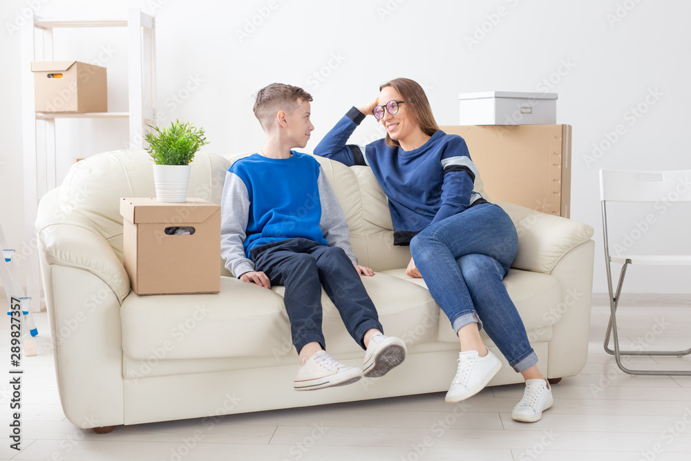 Charming pretty woman young single mother warmly communicates with her son discussing the new plan while moving to a new house