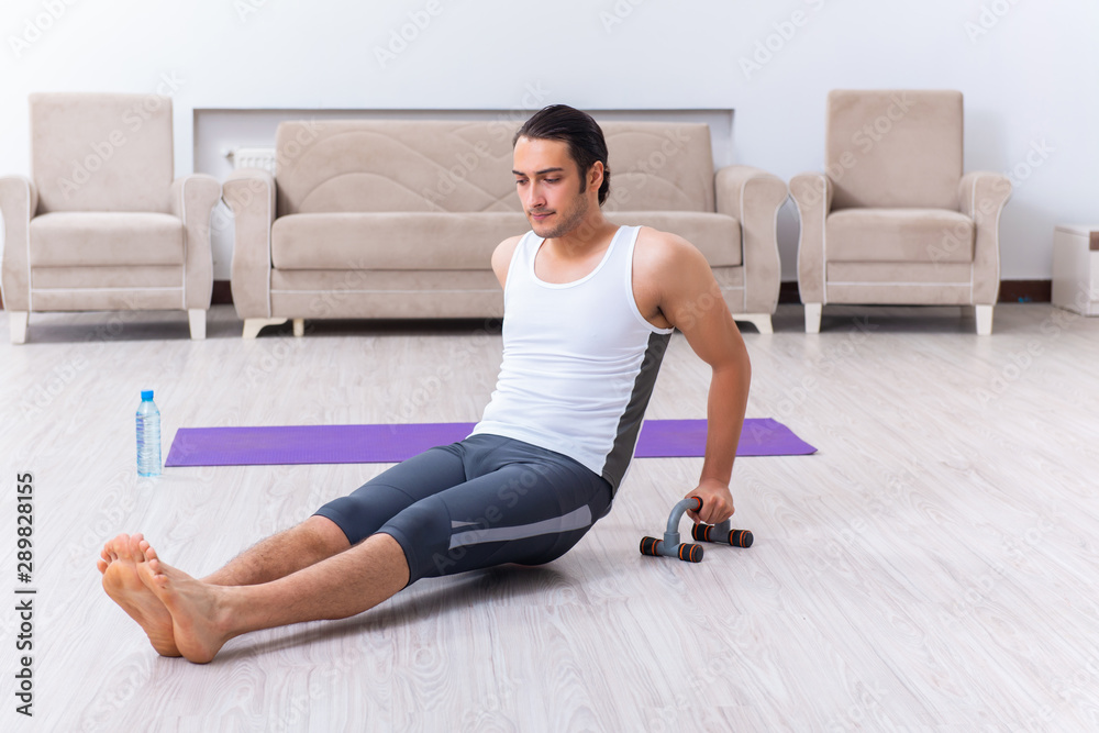 Fototapeta premium Young man training and exercising at home