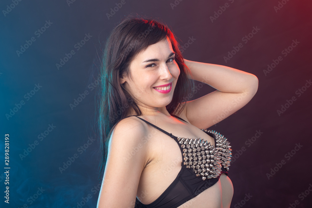 Fototapeta premium Alluring young beautiful brunette woman in a underwear posing on a dark background. Concept of seduction and sexual attractiveness