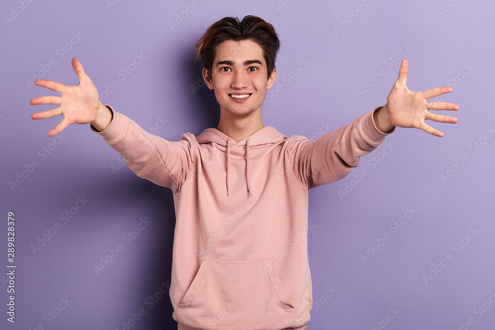 Young handsome cheerful man looking at the camera , standing with open arms for hug. Cheerful expression embracing happiness.love, guy expresses warm tender feeling and emotion Young handsome cheerful man looking at the camera , standing with open arms for hug. Cheerful expression embracing happiness.love, guy expresses warm tender feeling and emotion