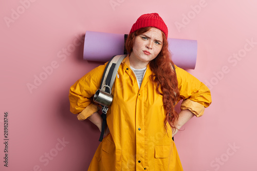 skeptic, unhappy, nervous hiker with hands on the hips expressing negative feeling . Negative person.close up portrait. isolated pink background