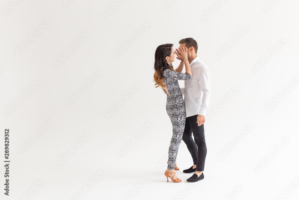 Skillful dancers performing in the white background with copy space. Sensual couple performing an artistic and emotional contemporary dance Skillful dancers performing in the white background with copy space. Sensual couple performing an artistic and emotional contemporary dance