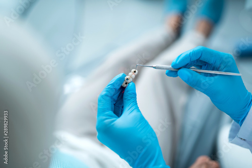 Dentist is holding dental instrument in clinic