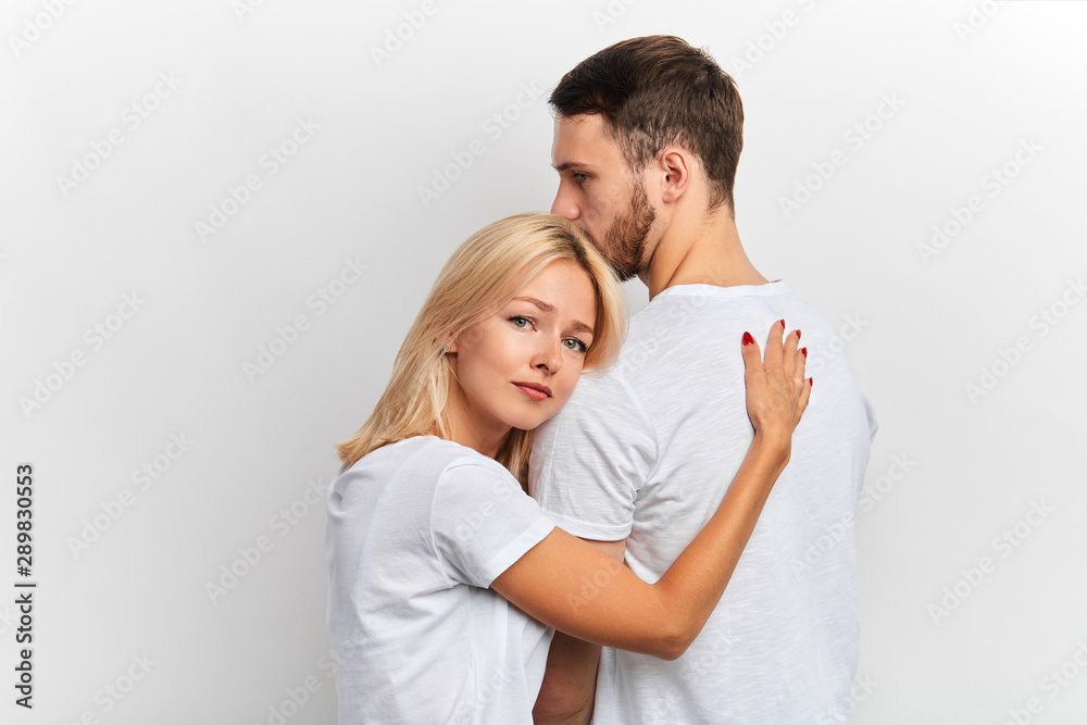 sad unhappy poor woman embracing her husband, they have to get divorced. isolated white background, studio shot sad unhappy poor woman embracing her husband, they have to get divorced. isolated white background, studio shot