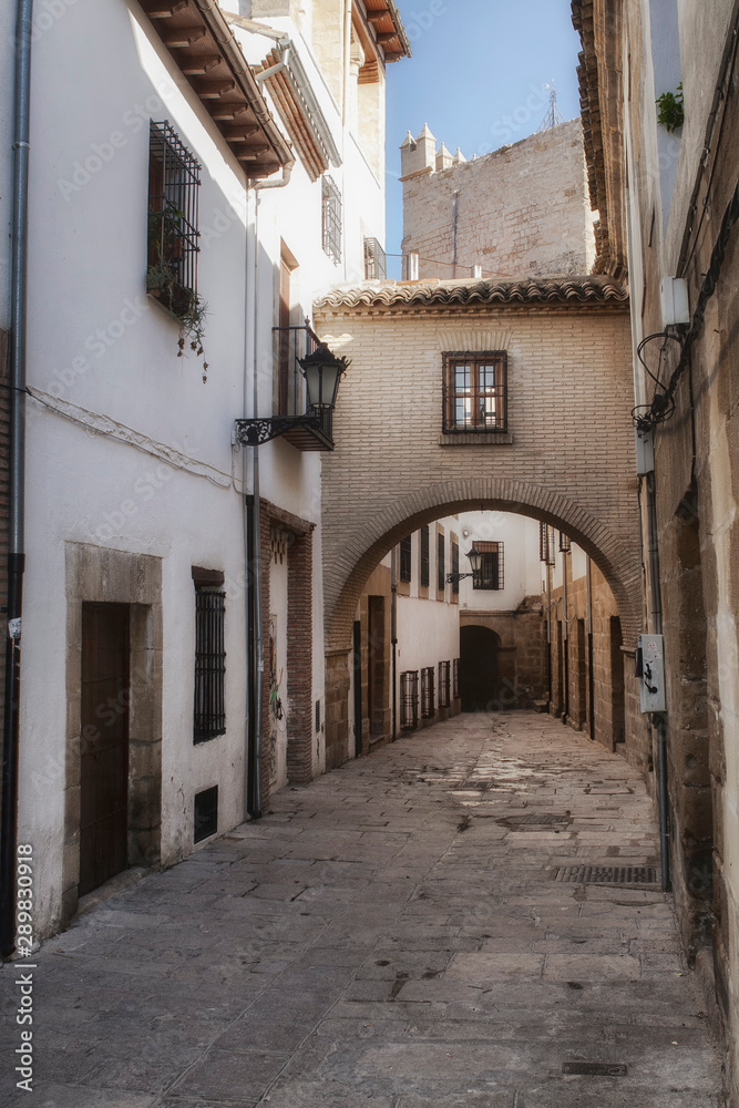 Typical Street of the world heritage city in Baeza, Street Barbacana next to the clock tower, It is characterized by the union of two houses with a passage, Baeza, Jaen province, Andalucia, Spain