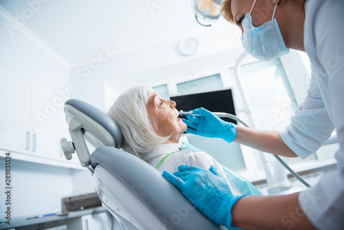 Dentist is using dental instruments during procedure