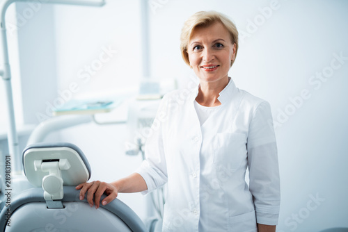 Female dentist is posing in dental office