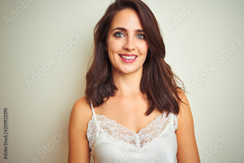 Young beautiful woman wearing t-shirt standing over white isolated background with a happy and cool smile on face. Lucky person.