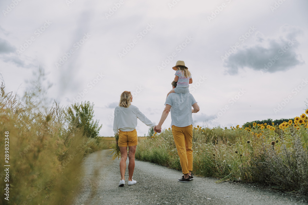 Beautiful young family keeping hands together on the road outdoors Beautiful young family keeping hands together on the road outdoors