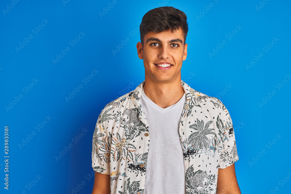 custom made wallpaper toronto digitalYoung indian man on vacation wearing hawiaian shirt standing over isolated blue background with a happy and cool smile on face. Lucky person.