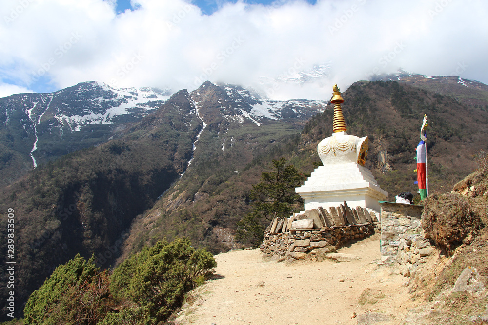 Old typical white Buddhist stupa (chorten) near Kisibook village in Himalayas in Nepal in Sagarmatha national park. Religion, architecture, healthy lifestyle, outdoors, travel and tourism concept.