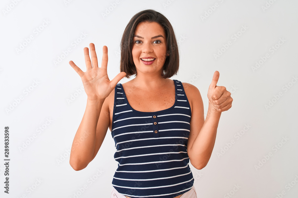 Young beautiful woman wearing blue striped t-shirt standing over isolated white background showing and pointing up with fingers number six while smiling confident and happy. Young beautiful woman wearing blue striped t-shirt standing over isolated white background showing and pointing up with fingers number six while smiling confident and happy.
