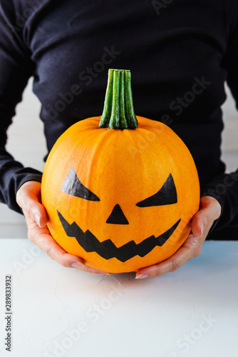 Halloween. Pumpkin in the hands on a light background. © 7707601