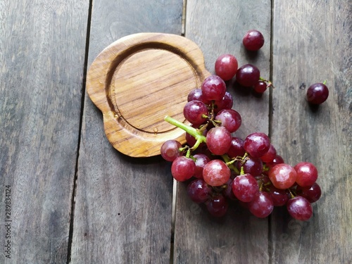 grape or red seedless grapes on wood background design concept in rustic