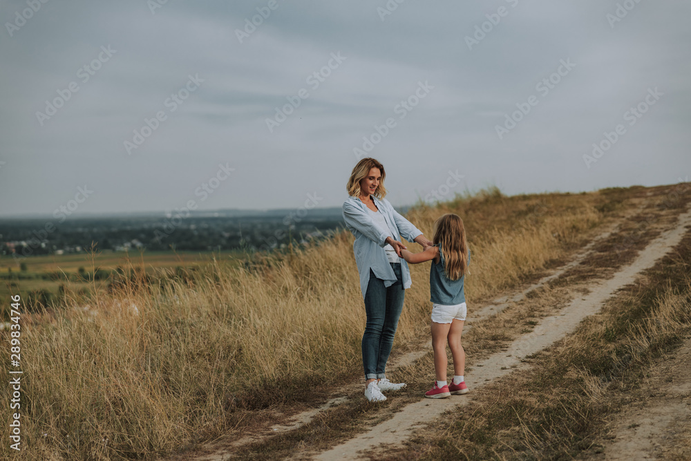Smiling mother and daughter are walking together