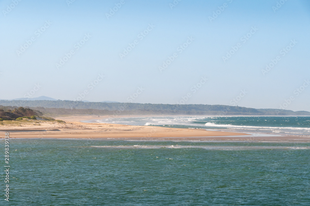 Summer beach landscape with sand coastline and mild waves Summer beach landscape with sand coastline and mild waves