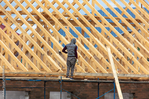Workers are building the roof of the house from wood © schankz