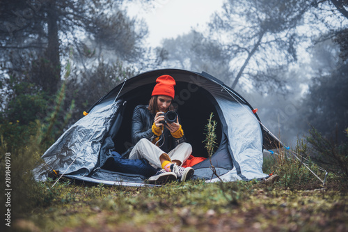 photographer tourist take photo on camera in camp tent on background foggy rain forest, hiker woman shooting mist nature trip, trekking tourism, rest vacation concept camping holiday, copy space