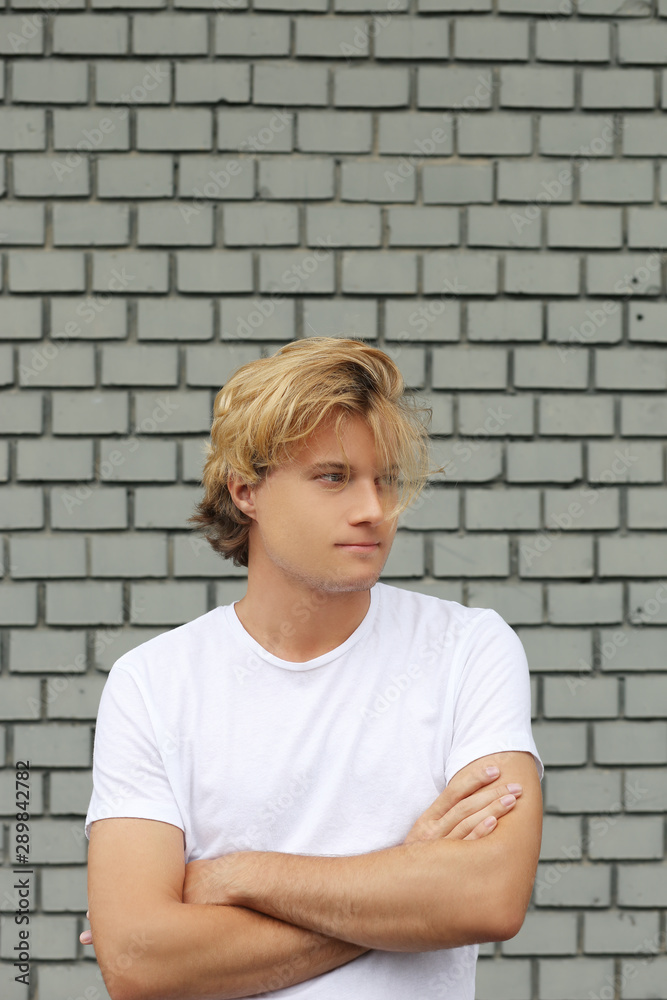 Teenager standing near a brick wall Teenager standing near a brick wall