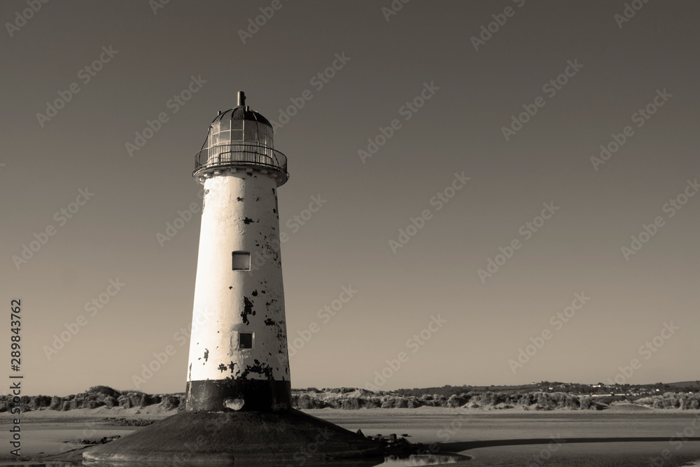 Point of Ayr lighthouse on a beach in North Wales.  With sepia colour toning