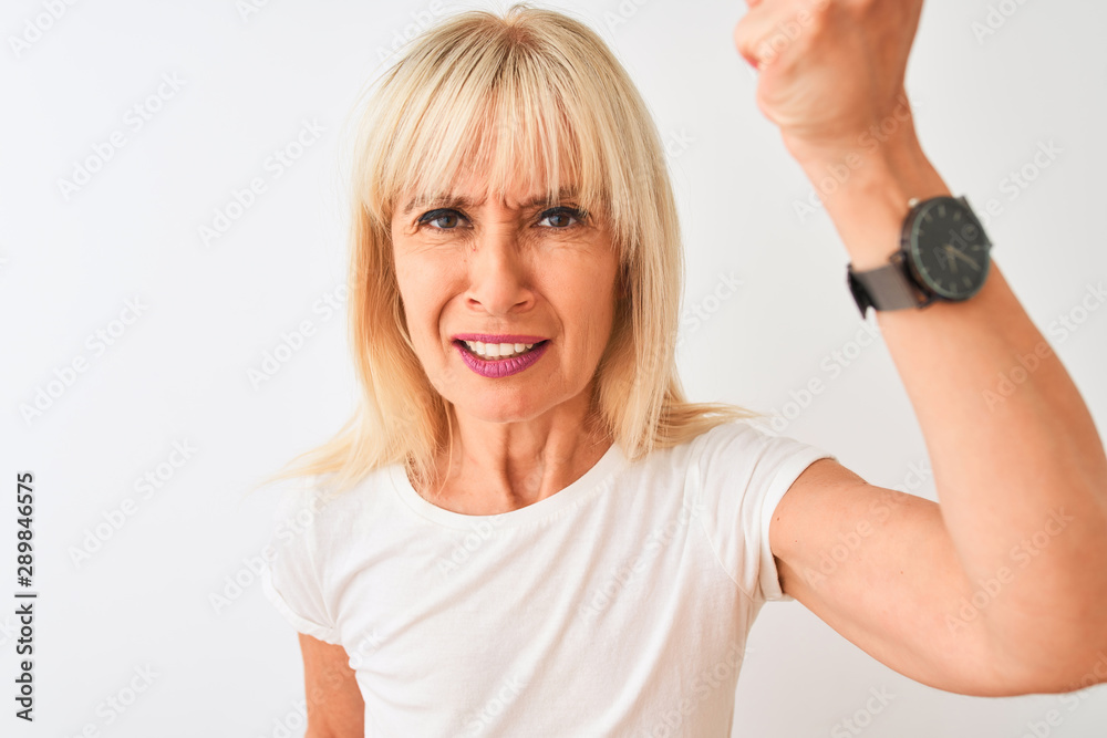 Middle age woman wearing casual t-shirt standing over isolated white background annoyed and frustrated shouting with anger, crazy and yelling with raised hand, anger concept Middle age woman wearing casual t-shirt standing over isolated white background annoyed and frustrated shouting with anger, crazy and yelling with raised hand, anger concept