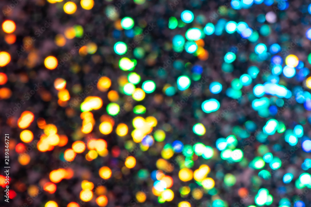 Naklejka premium Colorful prism confetti blurred festive bokeh backdrop, trendy sparkles and glitter background, flat lay. Christmas and holidays concept, 2020 new year celebration