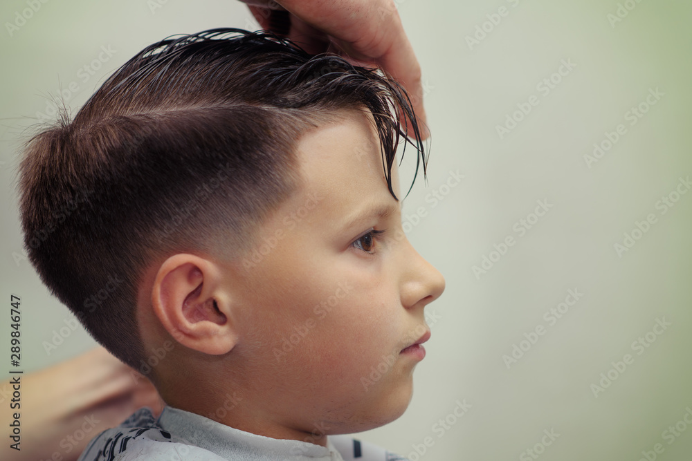 Barber is making hairstyle with hair gel to boy in barbershop. Stock Photo  | Adobe Stock