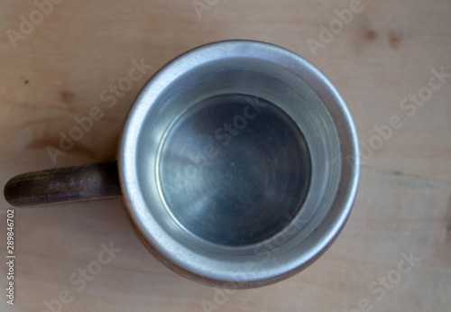 Metallic mug shot from the top. The base and the top of the cup are wooden.