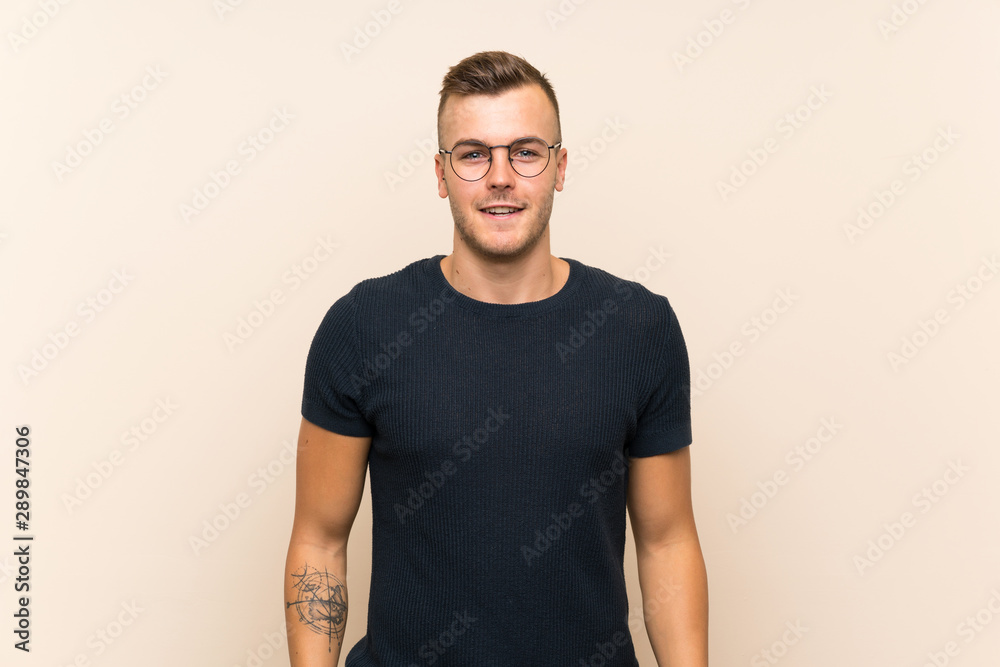 Young handsome blonde man over isolated background with glasses and happy Young handsome blonde man over isolated background with glasses and happy