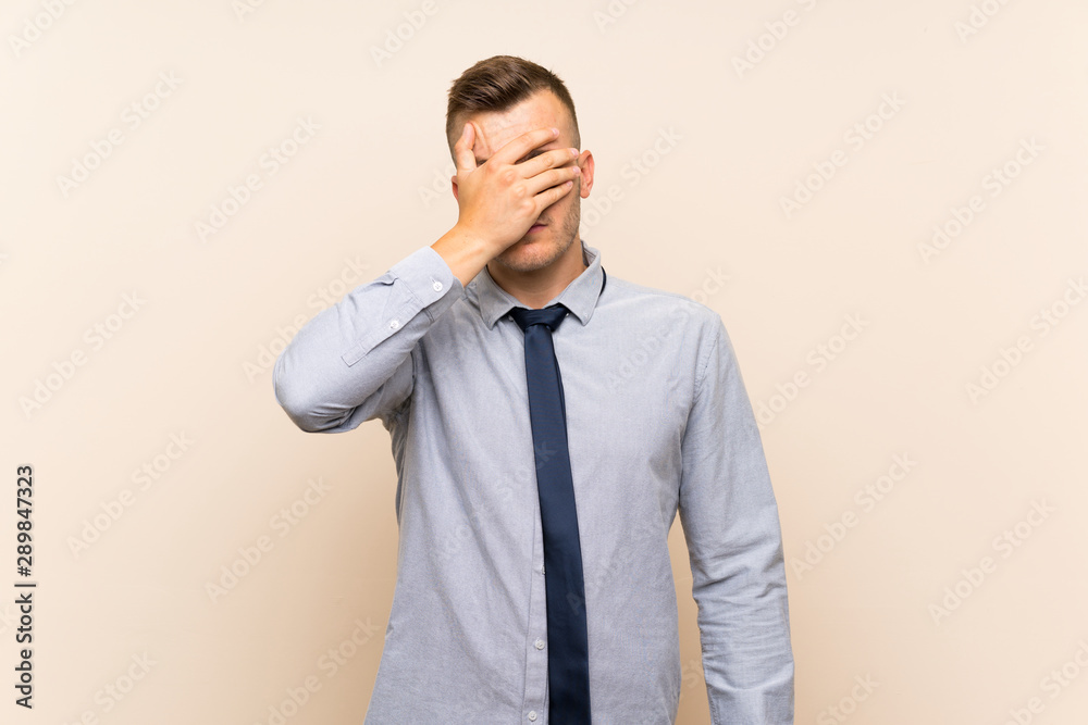 Young blonde businessman over isolated background covering eyes by hands Young blonde businessman over isolated background covering eyes by hands