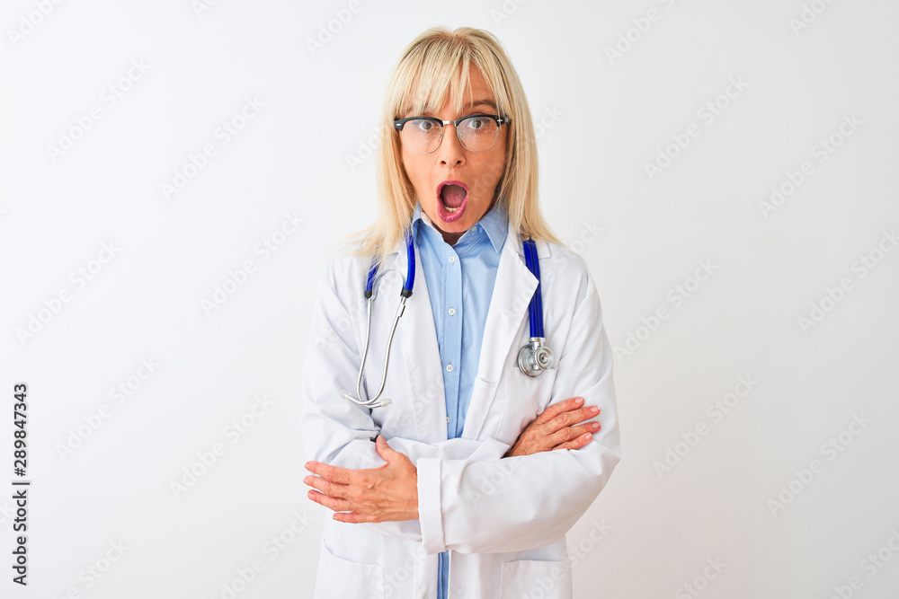 Middle age doctor woman wearing glasses and stethoscope over isolated white background afraid and shocked with surprise expression, fear and excited face. Middle age doctor woman wearing glasses and stethoscope over isolated white background afraid and shocked with surprise expression, fear and excited face.