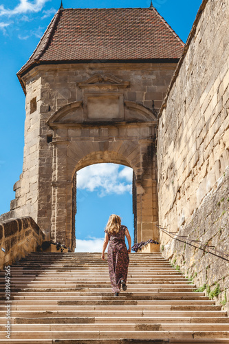 woman in a long dress is climbing the steps of the abbey of Saint Antoine