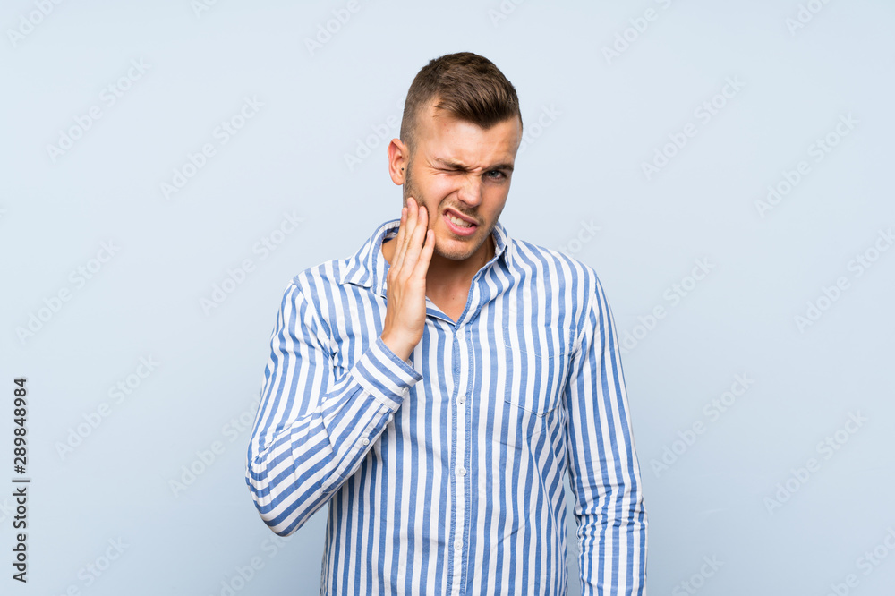 Young handsome blonde man over isolated blue background with toothache Young handsome blonde man over isolated blue background with toothache