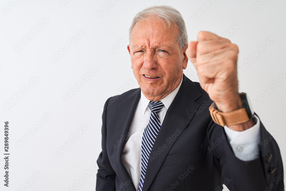 Senior grey-haired businessman wearing suit standing over isolated white background angry and mad raising fist frustrated and furious while shouting with anger. Rage and aggressive concept. Senior grey-haired businessman wearing suit standing over isolated white background angry and mad raising fist frustrated and furious while shouting with anger. Rage and aggressive concept.