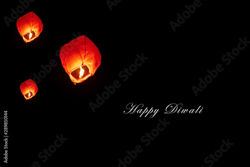 Happy Diwali - Fireflies Lantern. Diwali red sky Lanterns at night with space for text. People releasing sky lanterns to worship. Paper lamps flies up highly in the sky.