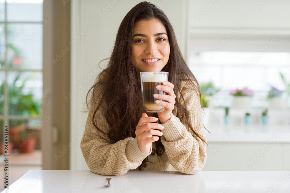Beautiful young girl drinking a cup of coffee at home and smiling Beautiful young girl drinking a cup of coffee at home and smiling