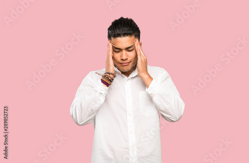 Young man with headache on colorful background
