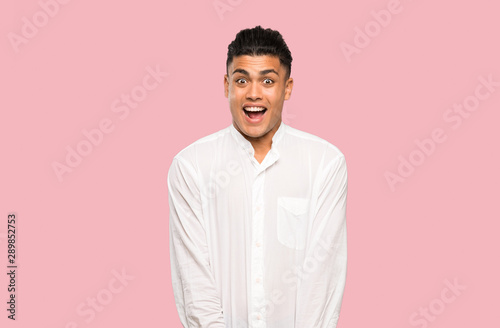 Young man with surprise facial expression on colorful background © luismolinero