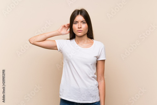 Pretty young girl over isolated background having doubts