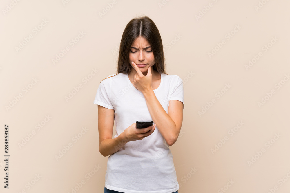 Pretty young girl over isolated background thinking and sending a message Pretty young girl over isolated background thinking and sending a message