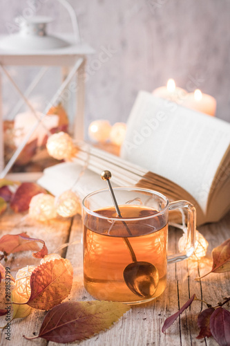 tea with books, candles, garland and autumn leaves