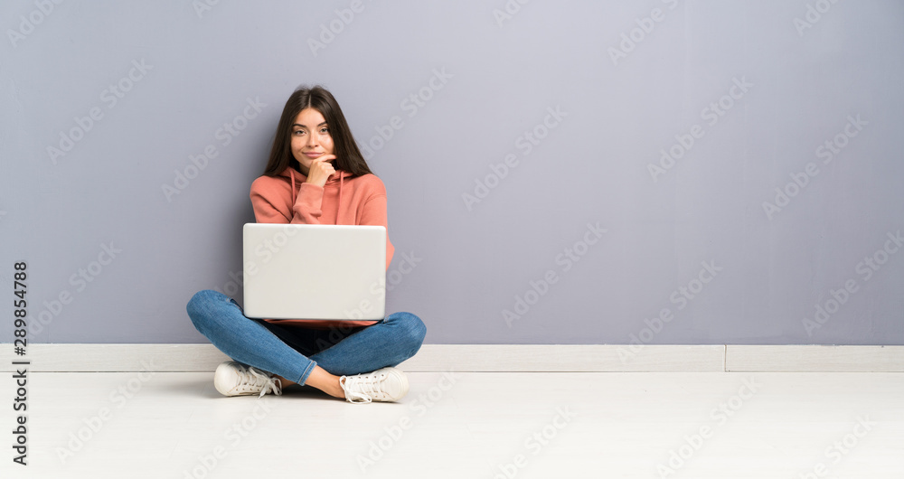 Young student girl with a laptop on the floor laughing Young student girl with a laptop on the floor laughing