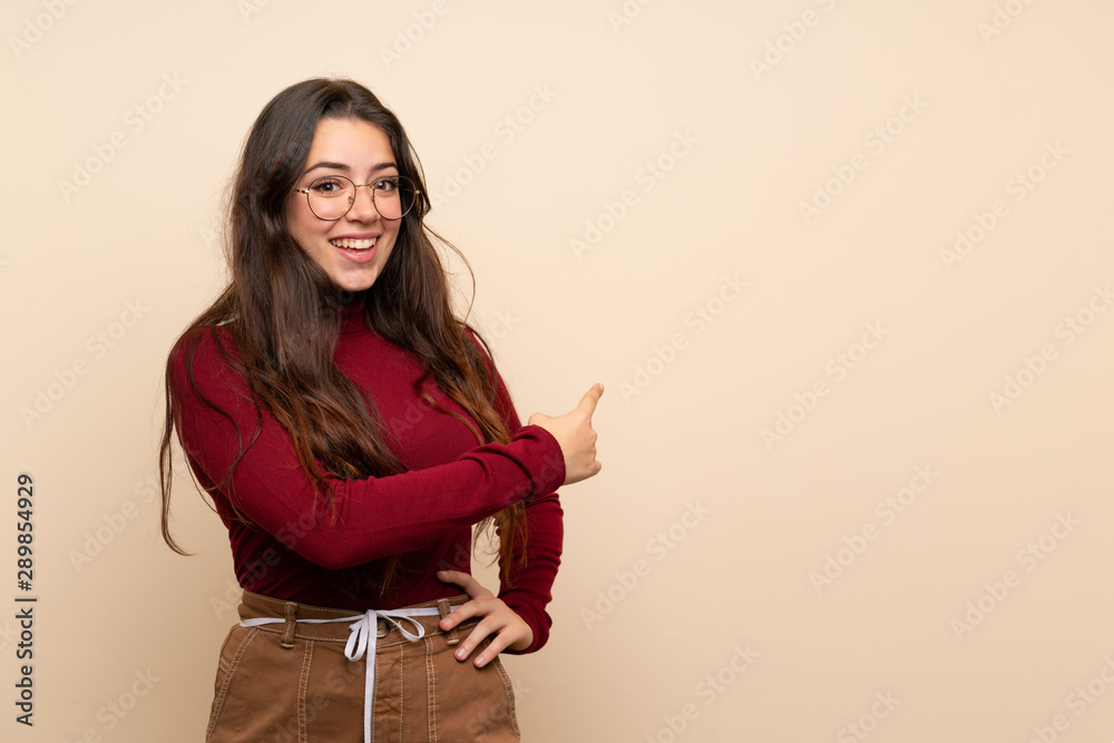 Teenager girl with glasses pointing back